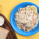 crab and shrimp linguine pasta in white sauce with a cheese board on the side