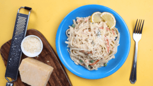 crab and shrimp linguine pasta in white sauce with a cheese board on the side