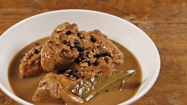 adobo sa gata in a white bowl