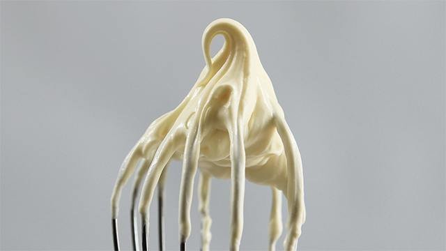 a whisk with whipped cream on top