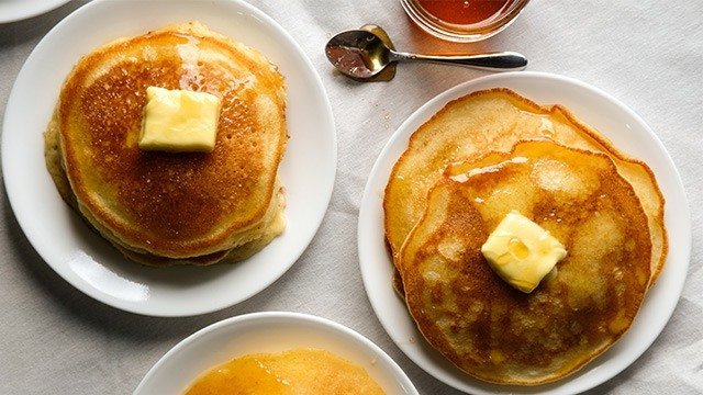 topshot of pancakes topped with butter and maple syrup