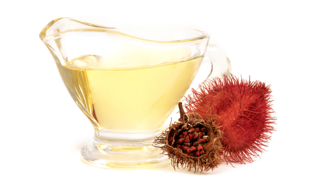 neutral oil in a glass pitcher and annatto fruit and seeds on the side