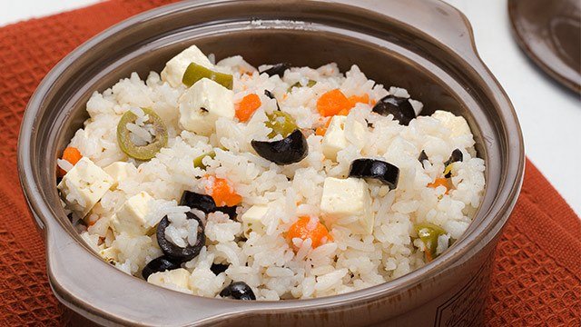 calamansi fried rice with tofu, green and black olives, and carrots in a bowl