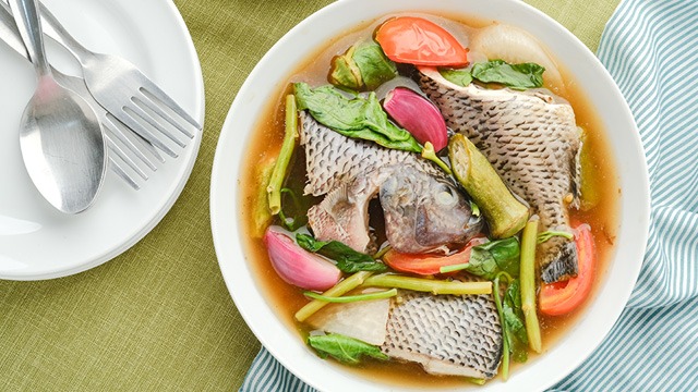 sinigang na tilapia in a white bowl