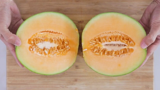 melon cut in half on a cutting board