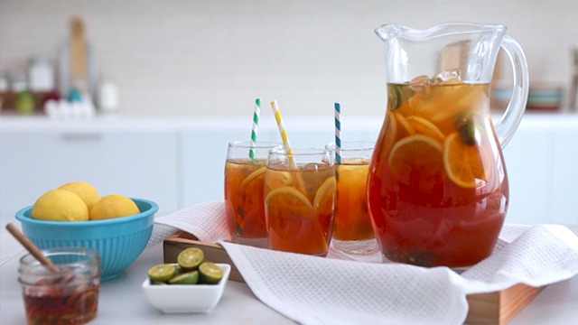 iced tea recipe in glasses with straws and a pitcher with lemon calamansi and honey on a tray