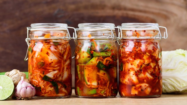 three glass jars containing kimchi