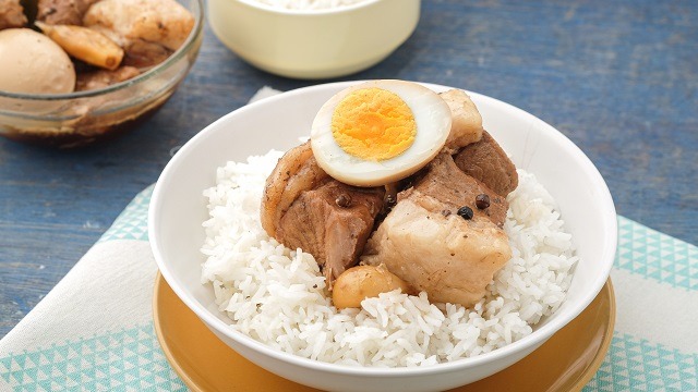 pork adobo with egg topped on a bowl of rice
