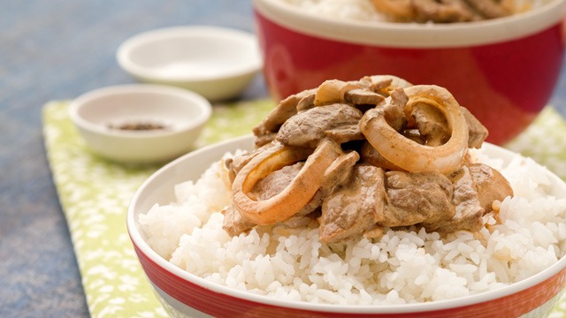 Creamy bistek or creamy beef steak on top of rice in a bowl