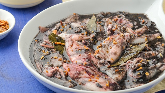 Adobong pusit sa gata or squid adobo with coconut milk in a white serving dish