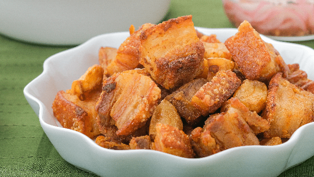 tulapho or crispy fried pork in a white bowl