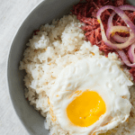 delicious morning breakfast corned beef with egg on top of rice