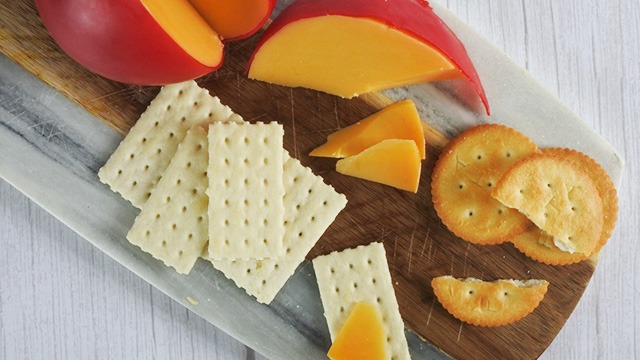 queso de bola, saltines, and milk crackers on a board