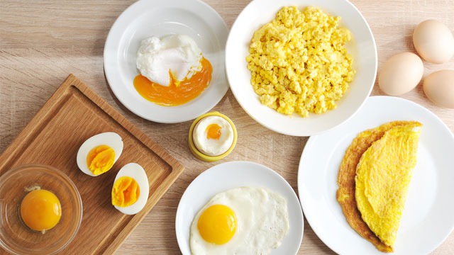 omelette, poached eggs, hard boiled eggs, fried eggs on a table