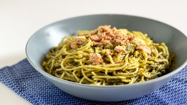tuna pesto pasta topped with tuna in a blue gray shallow bowl