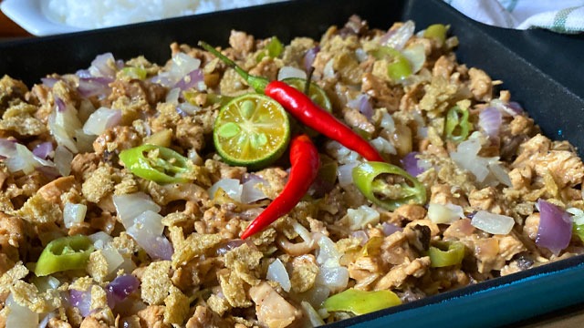 chicken sisig in a sizzling plate