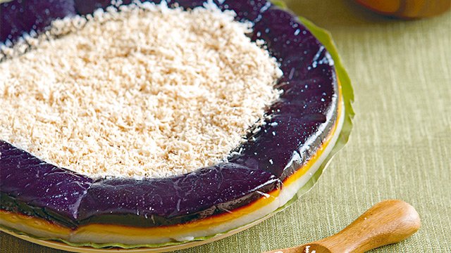 bilao of sapin-sapin topped with toasted coconut shavings
