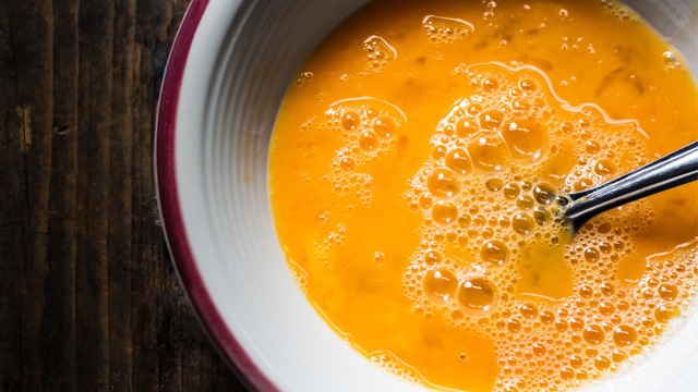 beaten eggs in a bowl with a fork