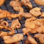 crispy chicken skin on a rack after frying