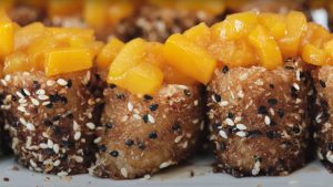 sugar-sesame-coated suman bites topped with flambeed mangoes