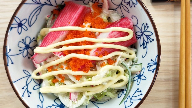 kani salad in a bowl with chopsticks on the side