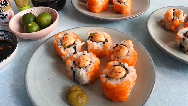spicy California maki on plates with calamansi, spicy mayo, togarashi, soy sauce as condiments