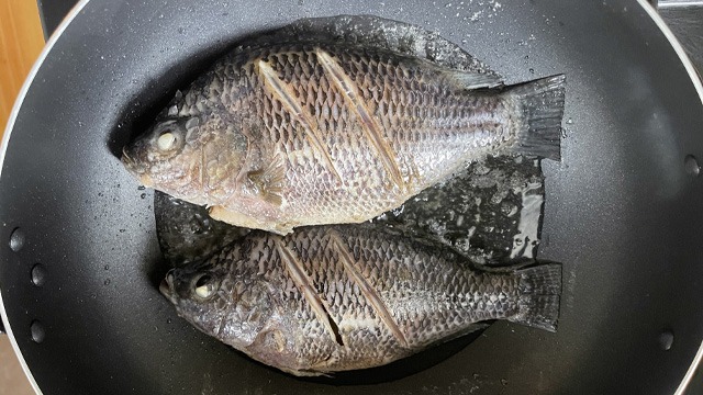 2 fish frying in a wok