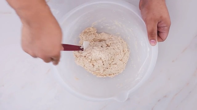 rough dough in mixing bowl with spatula
