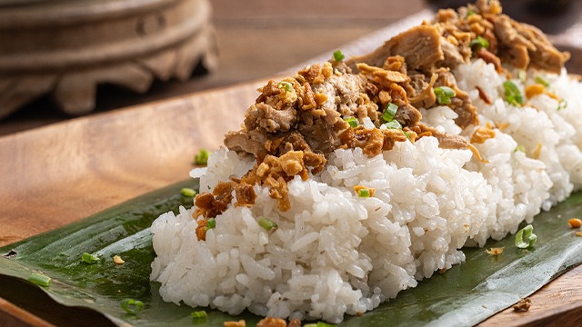Chicken pastil is made with seasoned shredded chicken on top of rice and wrapped in banana leaves.