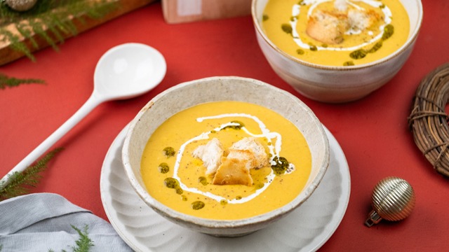 two cream of kalabasa soup bowls with croutons pesto and cream