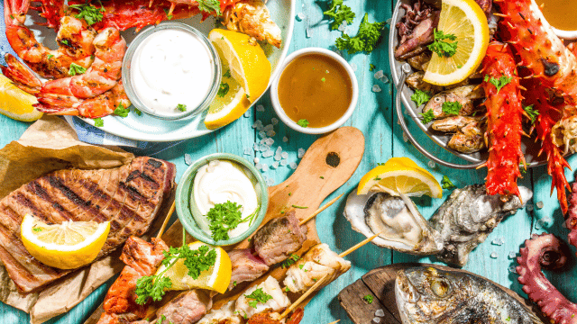 seafood dishes and sauces on a picnic table